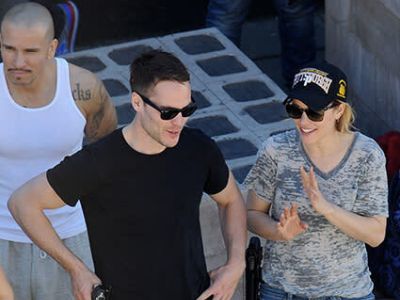 Both Taylor Kitsch and Rachel McAdams are wearing black shades as they are talking in the picture.